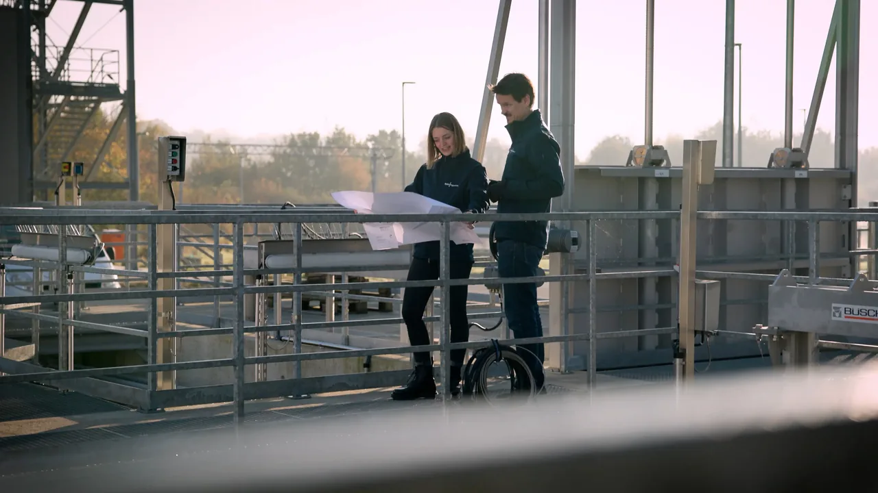 Zwei Ingenieure von Hydro-Ingenieure besprechen einen Plan auf der Anlage